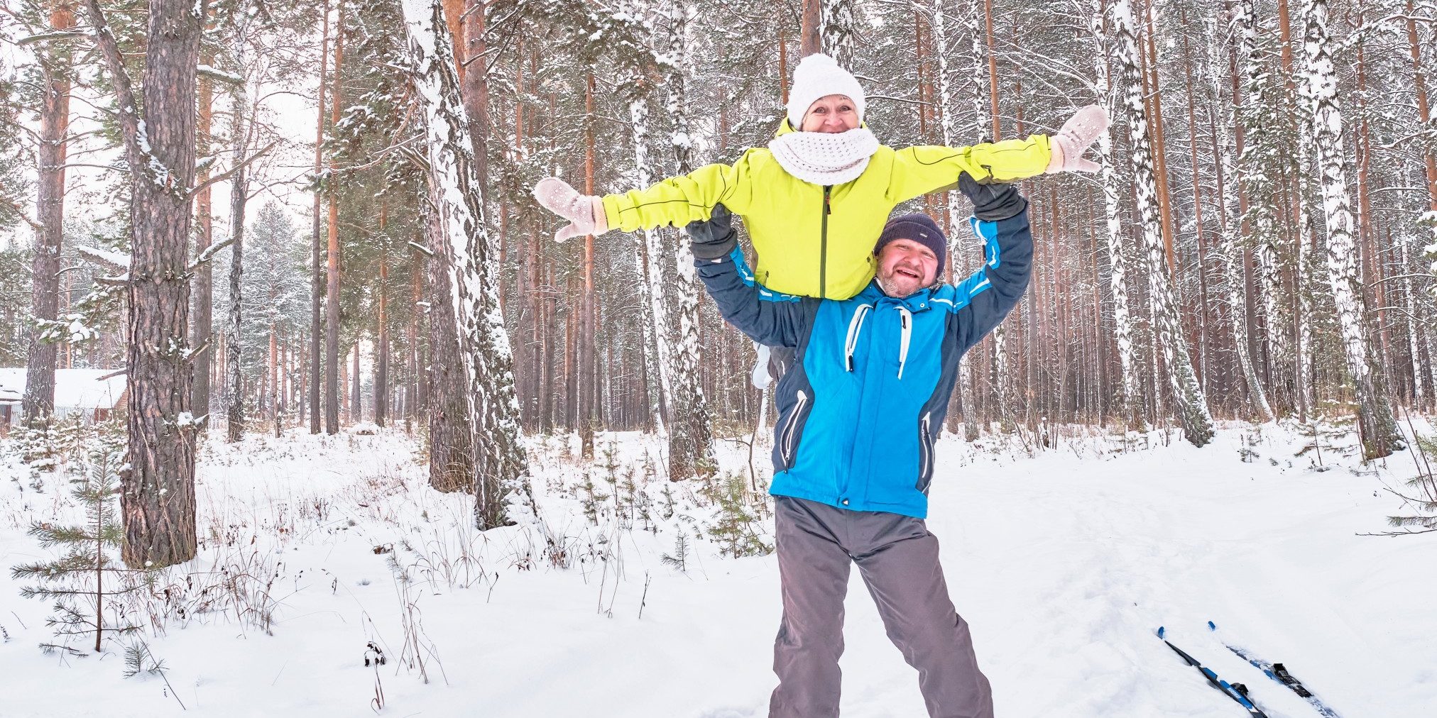 happy-mature-couple-in-winter-sportswear-having-fun-over-the-backdrop-of-a-snowy-forest-the-man_t20_gLYWXd