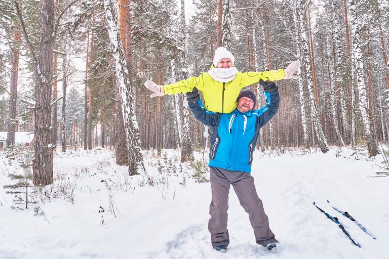 happy-mature-couple-in-winter-sportswear-having-fun-over-the-backdrop-of-a-snowy-forest-the-man_t20_gLYWXd